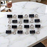 Pile of black metal binder clips 19mm size together