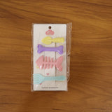 Young girl smiling wearing two cute cartoon hair clips showcasing real use.