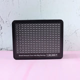 Close-up of money saving challenge board grid and black gel pen
